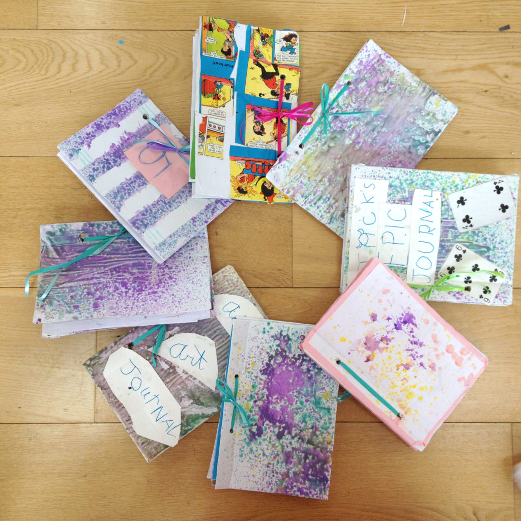 spray painting notebooks with kids at our summer camps 